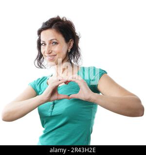 Frau mittleren Alters formt mit ihren Fingern eine Herzform Stockfoto