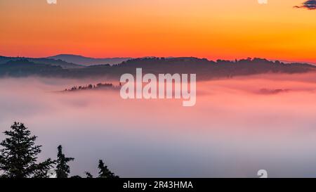 Am frühen Morgen überflutet Nebel die Täler der Toskana bei Sonnenaufgang Stockfoto