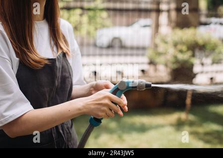 Handbewässerung des Rasens in der Nähe des Blumenladens. Nahaufnahme Stockfoto