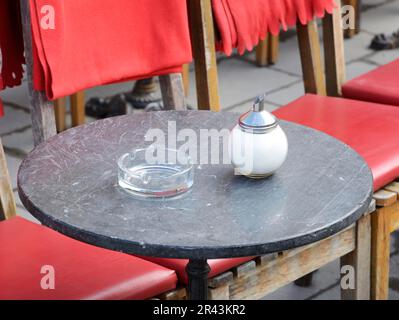 Aschenbecher und Zucker in einem Straßencafé auf Tisch Stockfoto