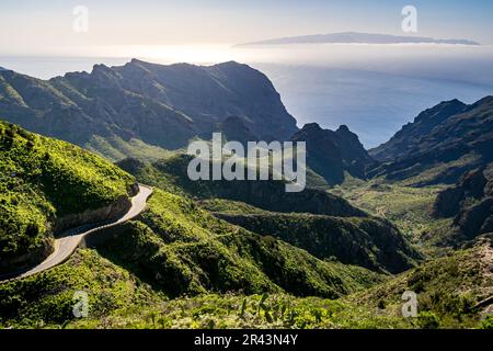 Erleben Sie die Teno Mountains auf der kurvenreichen TF-436 Straße, die Panoramablick auf den Atlantischen Ozean und die Insel La Gomera bietet, umgeben von grünem Erdboden Stockfoto