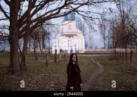 Eine Frau, die neben der Kirche steht Stockfoto
