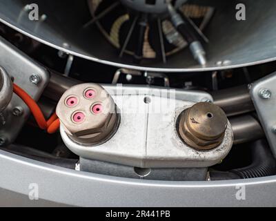 Vorderteil der Schneekanone auf einer Skipiste, Detail des Schutzgitters und der Klingen in einem Kanal. Detail eines verduckten Lüfters einer Schneekanone. Stockfoto