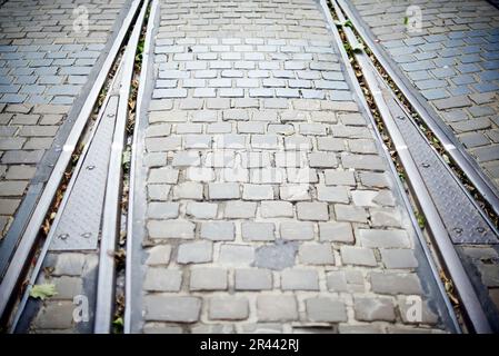 Kopfsteinpflaster auf der Straße und eine Straßenbahnlinie, die durch die Straße führt Stockfoto