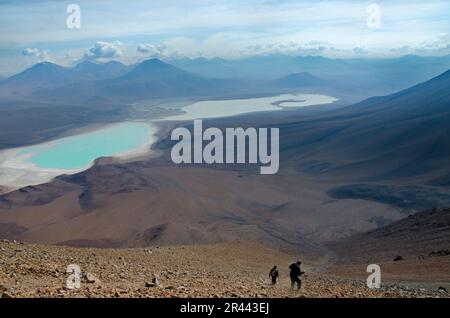 Wanderer gleiten den Berg hinunter in Richtung eines wunderschönen Sees Stockfoto