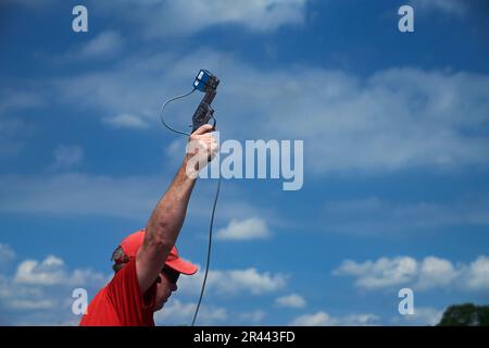 Nahaufnahme eines Beamten, der eine Waffe benutzt, um ein Sportwettbewerb zu starten Stockfoto