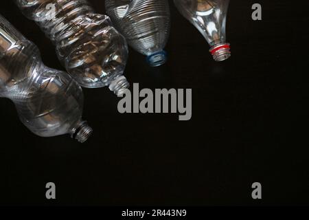 Schwarzer Hintergrund mit Kunststoffflaschen. Stockfoto