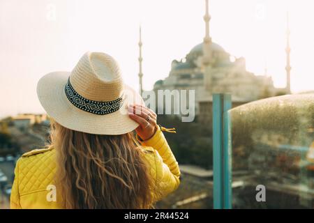 Eine junge Frau mit Hut sieht sich die Blaue Moschee an Stockfoto