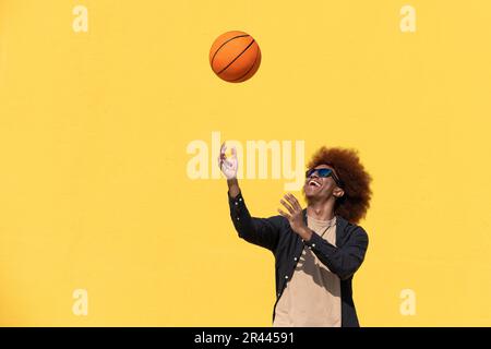 Fotoporträt eines Mannes, der Basketball in lässiger Kleidung spielt Stockfoto