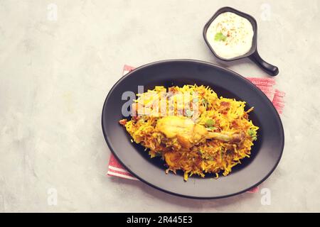 Hühnchen Biryani/murg Pulao. Garniert mit gebratenen Zwiebeln und gehacktem Koriander. Biryani serviert mit Rita ist ein berühmtes würziges nicht-vegetarisches Gericht Indiens. Stockfoto