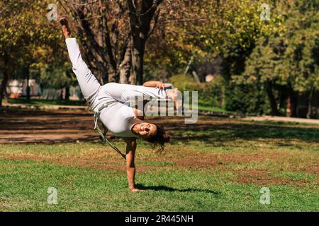 Süße brünette Frau, die Kicks, Sprünge und Capoeira auf der Straße macht Stockfoto