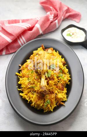 Hühnchen Biryani/murg Pulao. Garniert mit gebratenen Zwiebeln und gehacktem Koriander. Biryani serviert mit Rita ist ein berühmtes würziges nicht-vegetarisches Gericht Indiens. Stockfoto