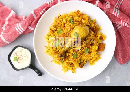 Hühnchen Biryani/murg Pulao. Garniert mit gebratenen Zwiebeln und gehacktem Koriander. Biryani serviert mit Rita ist ein berühmtes würziges nicht-vegetarisches Gericht Indiens. Stockfoto
