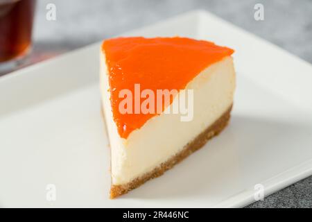 Kürbiskäsekuchen auf Porzellanteller mit Tee auf Steintisch Stockfoto