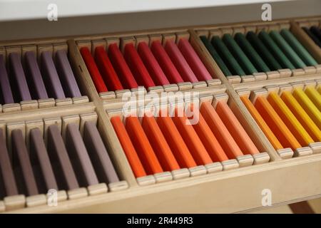 Holzkiste mit farbigen Tabletten im Regal, Nahaufnahme. Montessori Spielzeug Stockfoto