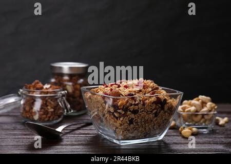 Leckeres Müsli mit Nüssen und trockenen Früchten auf einem Holztisch Stockfoto