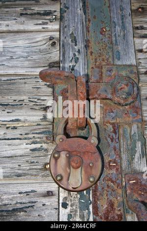 Rostige Vorhängeschloss auf einer alten Holztür Stockfoto