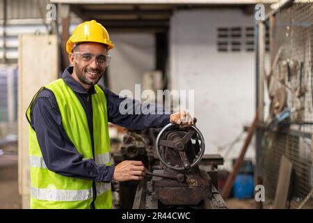 Hispanischer lateinamerikanischer ingenieur, männlicher Ingenieur, glückliches Lächeln, viel Spaß beim Arbeiten in einer Metalldreherfabrik Stockfoto