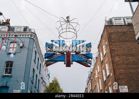 London, Vereinigtes Königreich - 13. April 2023: Großes Carnaby- und Union Jack 3D-Schild aus 30.000 rot-weiß-blau schimmernden Scheiben mit einer Krone speziell für die Koronatio Stockfoto