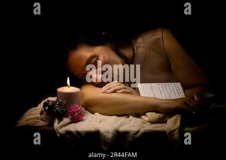 Eine Frau in romantischer Einstellung, die einen Liebesbrief II liest Stockfoto