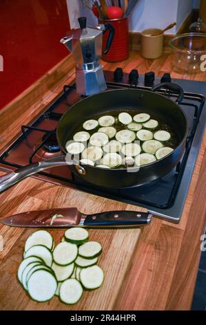 Braten oder Bräunen von Zucchini oder Zucchini in Sonnenblumenöl, fertig für ein italienisches Nudelgericht Stockfoto