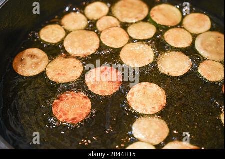 Braten oder Bräunen von Zucchini oder Zucchini in Sonnenblumenöl, fertig für ein italienisches Nudelgericht Stockfoto