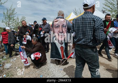 Nurdagi, Gaziantep, Türkei. 22. April 2023. Ein Mann trägt eine Flagge mit Präsident Recep Tayyip Erdogans Gesicht während der Kundgebung. Der türkische Präsident Recep Tayyip Erdogan, Führer der Partei für Gerechtigkeit und Entwicklung (AKP), nahm an einer Wahlkundgebung im Bezirk Nurdagi in der Provinz Gaziantep Teil. Das Stadtzentrum von Nurdagi wurde durch das doppelte Erdbeben am 06. Februar, das 11 Provinzen mit mehr als 50,000 Todesopfern in der Türkei heimsuchte, schwer zerstört. Die Rallye wurde zusammen mit einer Zeremonie organisiert, bei der die neuen Häuser für die vom Erdbeben betroffenen Menschen geliefert wurden. (Kreditbild: © Valeria Fe Stockfoto