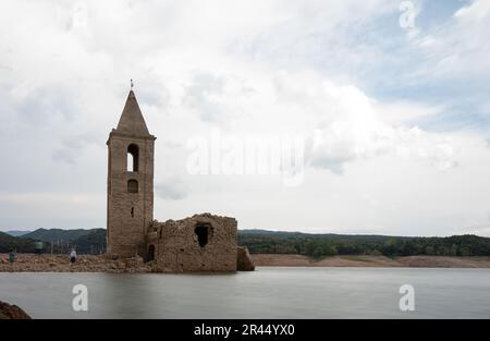 Langzeitaufnahmen der Kirche Sant Roma de Sau im Sau-Reservoir mit Seideneffekt und Menschen Stockfoto
