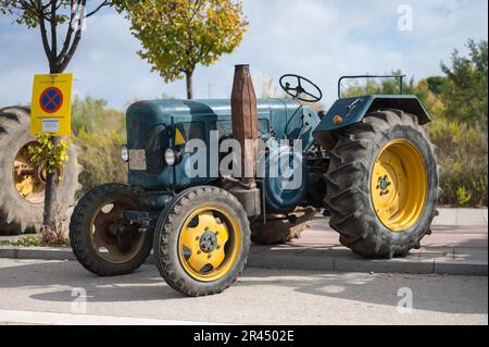 Vorderansicht eines schönen klassischen Traktors, ein grüner Lanz mit gelben Rädern, die auf der Straße geparkt sind Stockfoto