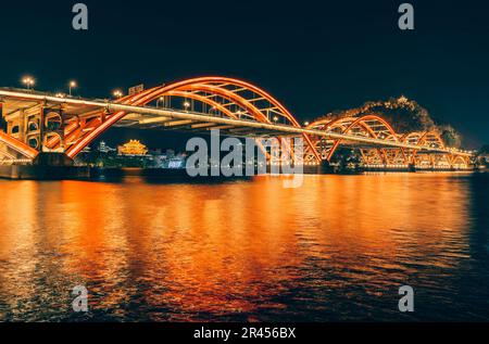 Der malerische Blick auf die Wenhui Bridge mit ihrer hellen Nachtbeleuchtung. Liuzhou, China. Stockfoto