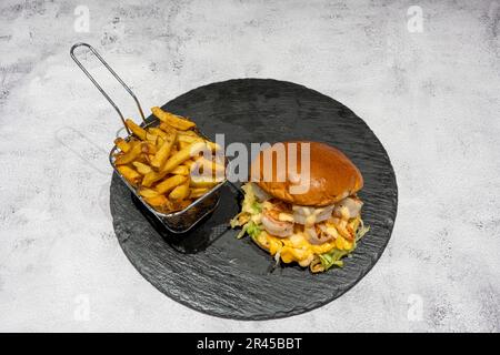 Indische Dishe kulinarisches Still Life. Gambas Cheese Burger serviert mit Pommes Frites auf einem Teller Stockfoto
