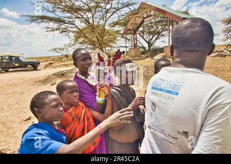 30. Dezember 2017, Serengeti-Nationalpark, Tansania-Maasai Kinder fragen an einem trockenen, heißen Tag nach Wasser von einem Safari-Reiseleiter Stockfoto