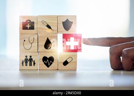 Hand man und Bausteine mit medizinischen Symbolen für Investitionen, Sicherheit und Versicherungsschutz. Finger, Wahl und Männlich mit Rätsel für das Gesundheitswesen Stockfoto