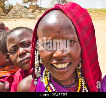 30. Dezember 2017, Serengeti-Nationalpark, Tansania - wunderschöne und natürliche Gesichter junger Maasai-Mädchen, die am Eingang des Serengeti-Nationalparks mit Touristen interagieren Stockfoto