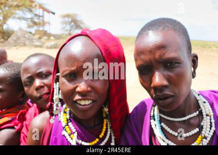 30. Dezember 2017, Serengeti-Nationalpark, Tansania - wunderschöne und natürliche Gesichter junger Maasai-Mädchen, die am Eingang des Serengeti-Nationalparks mit Touristen interagieren Stockfoto