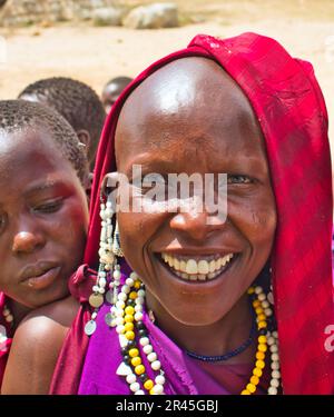 30. Dezember 2017, Serengeti-Nationalpark, Tansania - wunderschöne und natürliche Gesichter junger Maasai-Mädchen, die am Eingang des Serengeti-Nationalparks mit Touristen interagieren Stockfoto