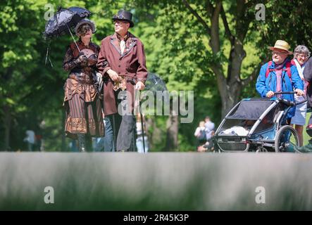 Leipzig, Deutschland. 26. Mai 2023. Teilnehmer des Wave-Gotik-Treffens (WGT) machen einen Spaziergang durch den Clara-Zetkin-Park zum traditionellen viktorianischen Picknick. Was in den frühen 90s Jahren mit einer Handvoll Bands in einem kleinen Club begann, ist zu dem wahrscheinlich größten Festival der dunklen Szene der Welt geworden: Das Wave-Gotik-Treffen feiert in diesem Jahr seinen 30. Jahrestag. Bis zum Pfingstmontag erwarten die Organisatoren rund 20.000 Besucher aus Deutschland und dem Ausland. Kredit: Jan Woitas/dpa/Alamy Live News Stockfoto