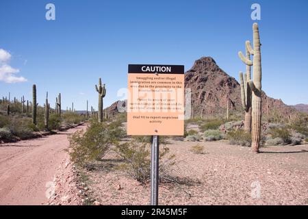 Schild mit Warnung vor gefährlichen illegalen Aktivitäten in der Nähe der internationalen Grenze zwischen den USA und Mexiko im Organ Pipe Cactus National Monument, Ajo, Lukeville, Arizona, Stockfoto