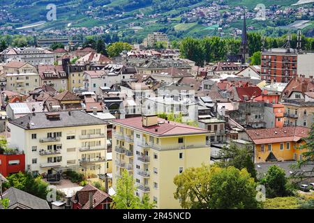 Ein Blick aus der Vogelperspektive auf eine städtische Landschaft mit hohen Gebäuden in den sanften Hügeln in Meran, Südtirol Stockfoto