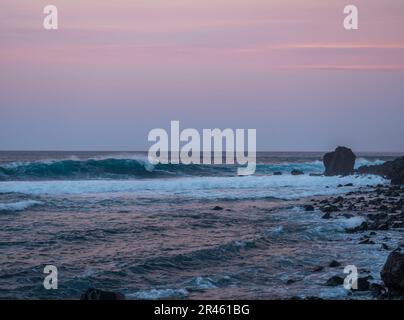 Malerischer Blick auf den rosa Sonnenuntergang am vulkanischen Sandstrand Playa del Ingles in Valle Gran Rey, La Gomera, Kanarische Inseln, Spanien, Europa. Blaue grüne Wellen Stockfoto