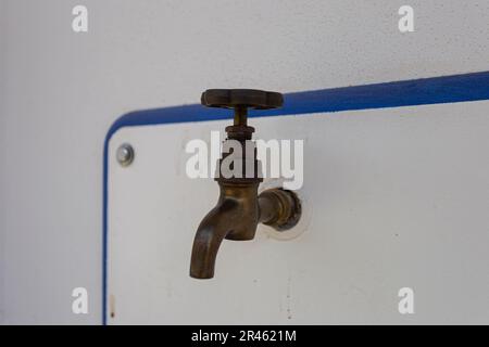 Ein alter Wasserhahn auf einem gusseisernen Waschbecken im Hof des Hauses Stockfoto