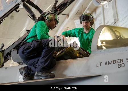 Aviation Structural Mechanic (Safety Equipment) 3. Class Kaylen Hughes, Left, aus Memphis, Tennessee, Und Aviation Structural Mechanic (Sicherheitsausrüstung) 1. Klasse Bradley Marshall aus Cleveland, die beide dem ÒBlacklionsÓ der Streikkkampfstaffel (VFA) 213 zugeteilt sind, installieren einen Auswurfsitz in einem F/A-18F Super Hornet, in der Hangarbucht des ersten Flugzeugträgers USS Gerald R. Ford (CVN 78), 26. März 2023. Ford ist im Atlantik dabei, seine Composite Training Unit Exercise (COMPTUEX) durchzuführen, eine intensive, mehrwöchige Übung, die darauf ausgelegt ist, einen Carrier str vollständig zu integrieren Stockfoto