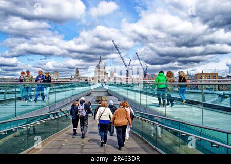 Blick auf London von der Millennium Footbridge in Richtung St Pauls Cathedral und Walkers auf der Brücke Stockfoto