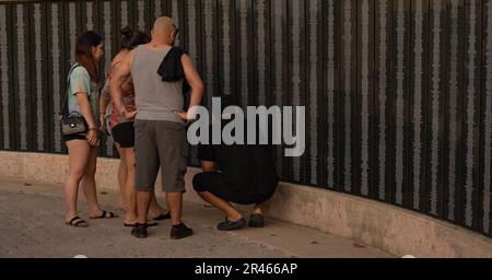 Familienmitglieder der Chamorro-Familie sehen sich die Namen von Familienmitgliedern an, die während des Zweiten Weltkriegs beim US-Militär gedient haben, im National Historical Park, Asan Bay Overlook, Asan, Guam, 17. Januar, 2023. In der Bucht von Asan wurden Vorräte und Ausrüstung auf Schiffe geladen, um Amerikas Inselhüpfkampagne auf die Insel Japan zu unterstützen, auf der 1944 zahlreiche Mitglieder des Dienstes starben. Die Militärpräsenz in Guam spielt heute eine wesentliche Rolle bei dem Ziel des 38. Befehlshabers des 2030. Truppenentwurfs des Marinekorps, die Mission des Marinekorps in den Indo-Pazifik zu verlagern. Stockfoto