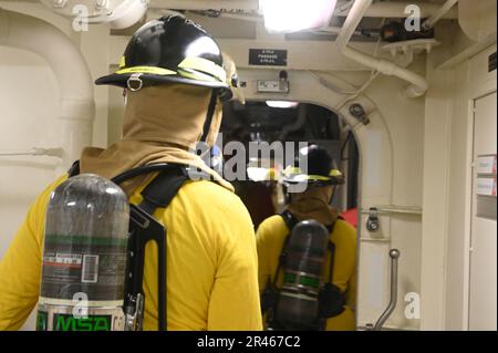 Besatzungsmitglieder der USCGC Stone (WMSL 758) reagieren auf einen simulierten Brand während einer Übung an Bord des Stones im Südatlantik am 13. März 2023. Stone ist im Südatlantik im Einsatz, um illegale maritime Aktivitäten zu bekämpfen und die Beziehungen zur maritimen Souveränität in der gesamten Region zu stärken. Stockfoto