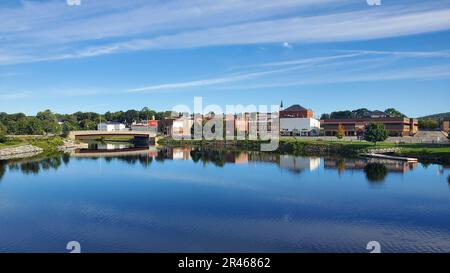 Eine idyllische Szene einer kleinen Stadt auf dem Land mit einem Fluss, der sich durch die Mitte des Bildes schlängelt Stockfoto