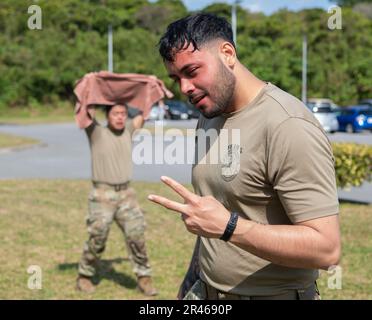 Airman 1. Class Andres Solis, 18. Security Forces Squadron Defender, posiert während der Genesung, nachdem er den Oleoresin Capiscum Kurs am Kadena Air Base, Japan, am 6. März 2023 absolviert hatte. Die Wirkung von OC-Spray kann im Durchschnitt 30 Minuten nach der Anwendung anhalten. Stockfoto