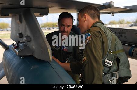 Von links, USA Oberstleutnant Jason Ulibri, Ausbilderpilot, und 1. Leutnant Eric Murray, ein Studentenpilot, die beide dem 149. Kampfflügel der Air National Guard zugeteilt wurden, führen vor dem Start während der Coronet Cactus, 30. März 2023, auf dem Luftwaffenstützpunkt Davis Monthan, Arizona, Vorflugkontrollen durch. Bei der jährlichen Trainingsveranstaltung werden Mitglieder des 149. Fighter Wing mit Hauptsitz auf der Joint Base San Antonio-Lackland, Texas, in eine andere Umgebung entsandt, um sie mit dem Erreichen von Missionszielen an einem unbekannten Ort vertraut zu machen. Stockfoto