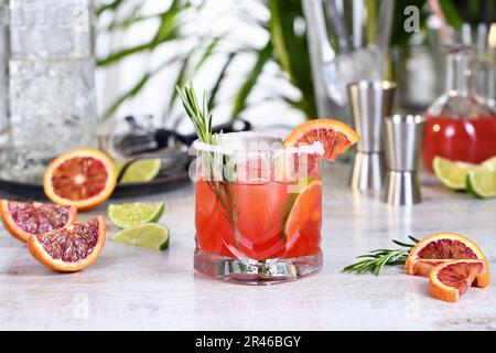 Roter sizilianischer Orange Paloma Cocktail mit Tequila, frischer Limette und Rosmarin mit rotem sizilianischem Orangensaft. Dieser Cocktail ist voller heller Zitrusaromen Stockfoto