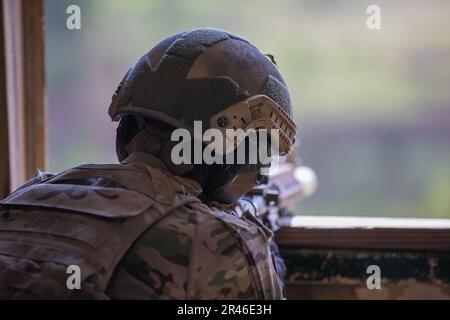 SPC. Tyler Wischerman, Soldat des 2. Geschwaders, 1. Kavallerie-Regiment, 1. Stryker-Brigade-Kampfteam, 4. Infanterie-Division, greift das Ziel während des internationalen Sniper-Wettbewerbs 2023 in Fort Benning, Georgia, am 11. April 2023 an. Die Scharfschützen beim Wettkampf mussten wichtige Kampffähigkeiten unter Beweis stellen, einschließlich Tarnung, Aufklärung, Fitness und die Fähigkeit, sich unter Druck anzupassen. Stockfoto